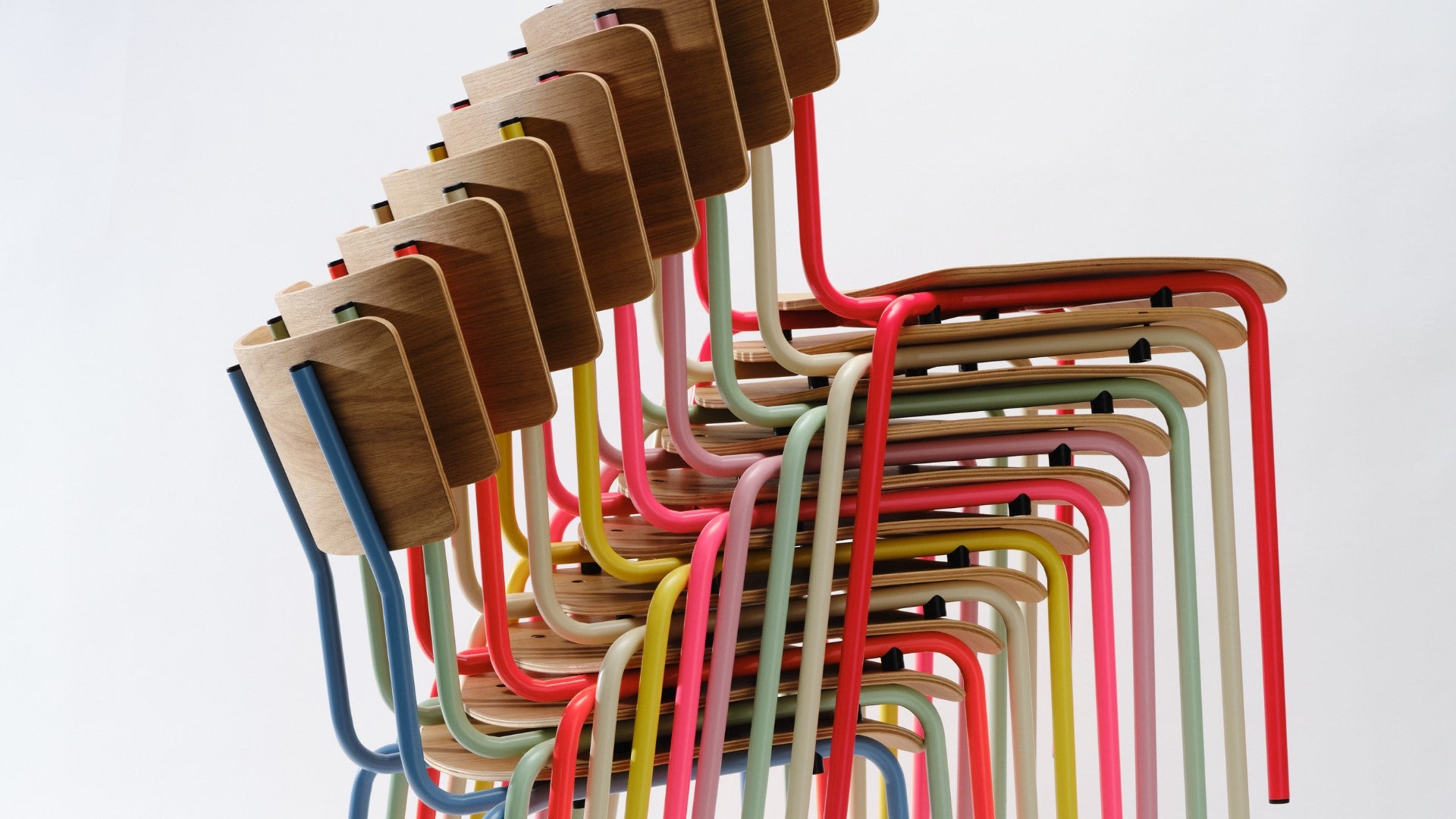 Bunte stapelbare Designstühle von Bensberger mit Sitzflächen aus Eichenholz und farbig pulverbeschichtetem Stahlrohrgestell.